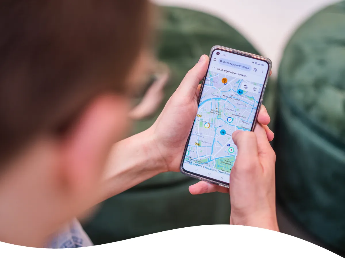 Foto van gebruiker met telefoon in handen waar Mappi op getoond wordt